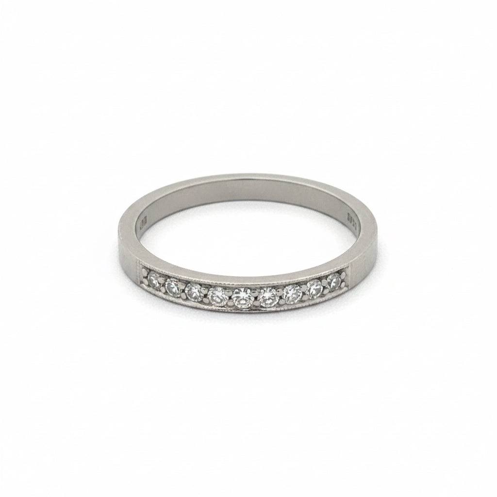 Vintage diamond milgrain wedding band in 14k white gold featuring intricate milgrain detailing and a row of sparkling diamonds.