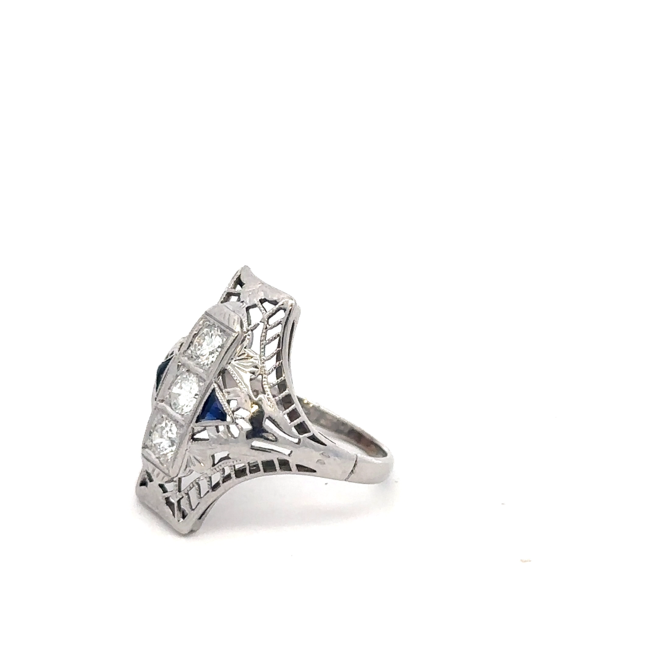 Art deco shield ring by Silver Lady Vintage featuring a sapphire and diamond set in 18k white gold, with intricate vintage design.