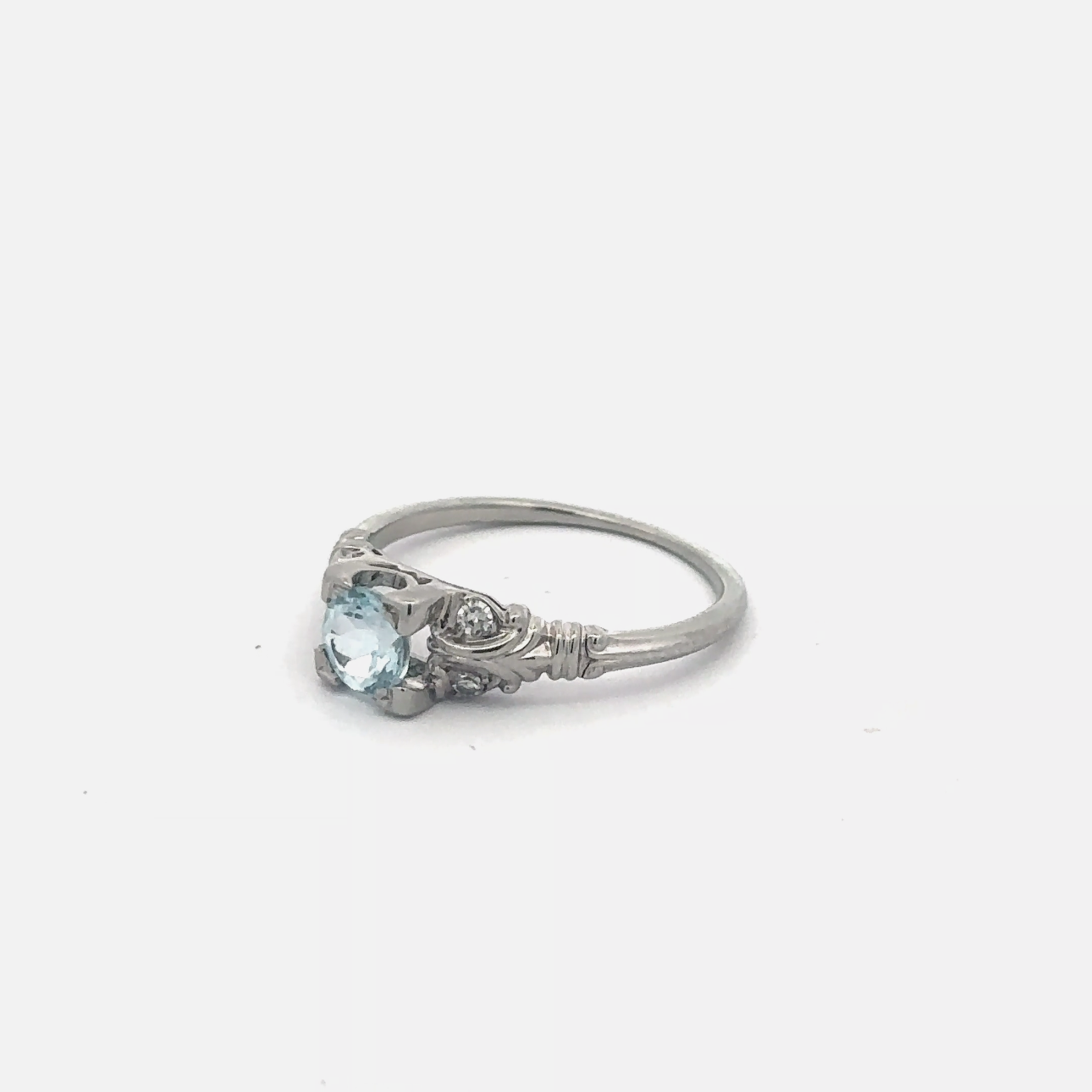 Vintage aquamarine solitaire ring in 18k white gold with a silver lady vintage style design, featuring a central aquamarine gemstone.