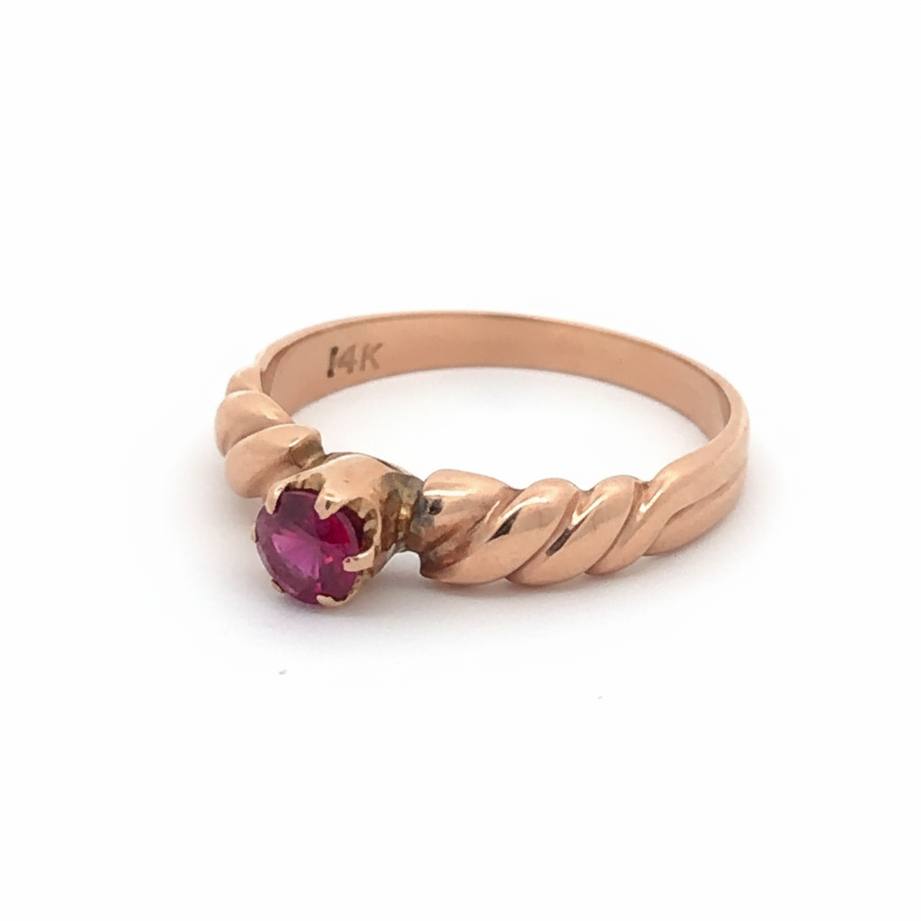 Victorian ruby solitaire ring in 14K rose gold featuring a central ruby gemstone and intricate vintage design.