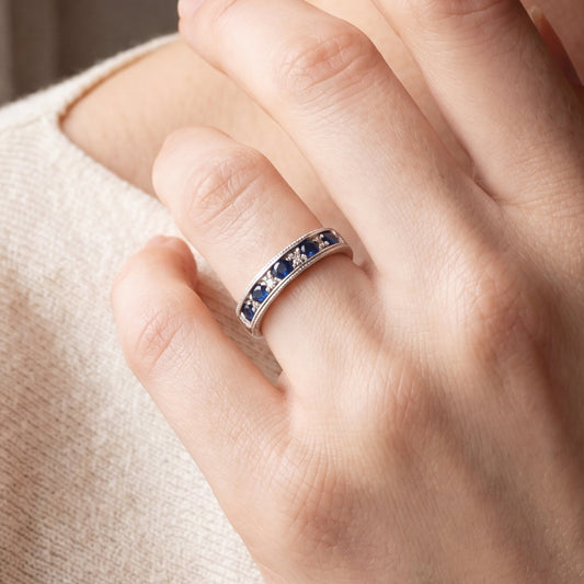 Vintage sapphire and diamond band in 14k white gold, featuring intricate detailing and a classic design.