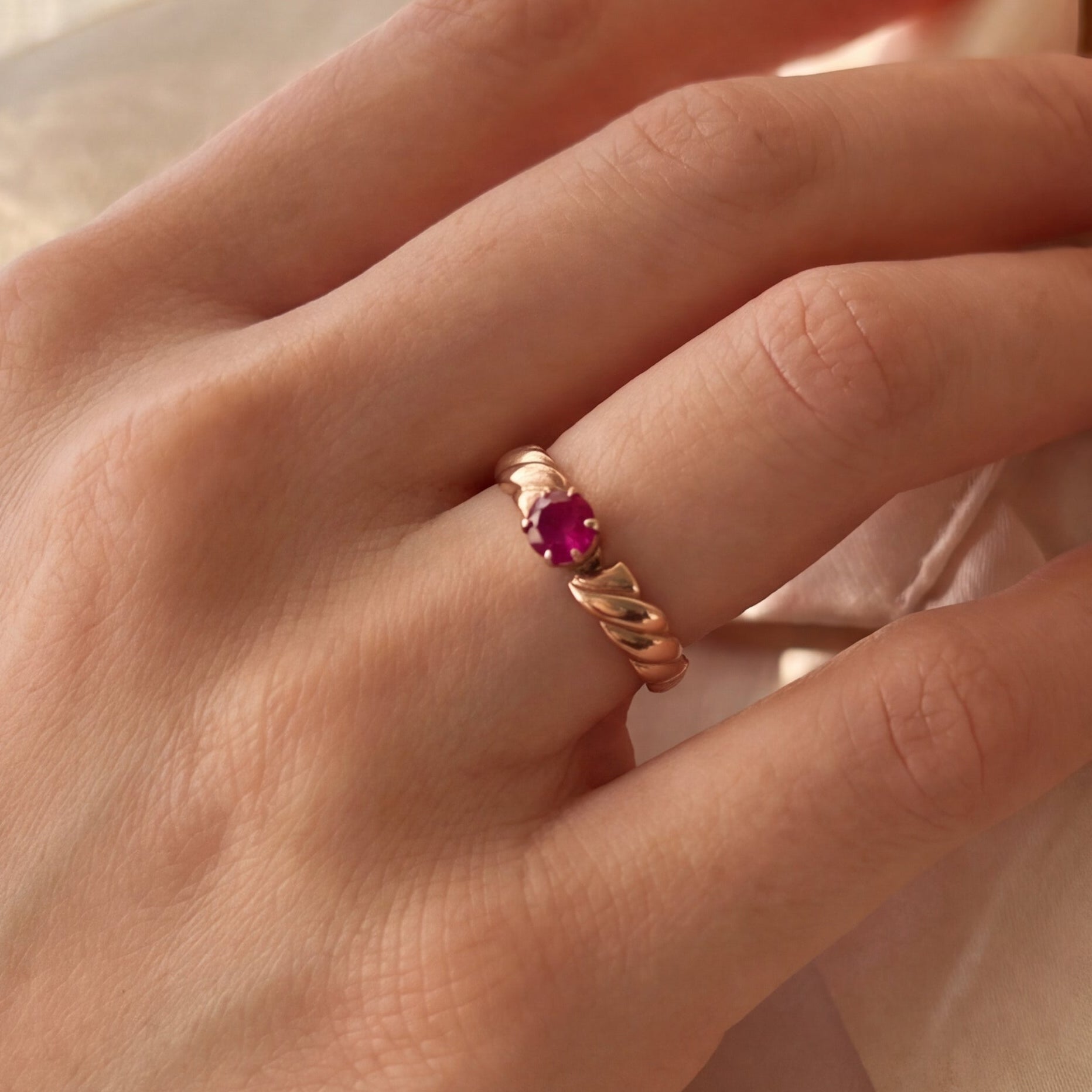 Victorian ruby solitaire ring in 14K rose gold with intricate vintage detailing, featuring a central ruby gemstone.